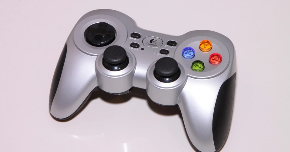 A silver game controller on a white surface