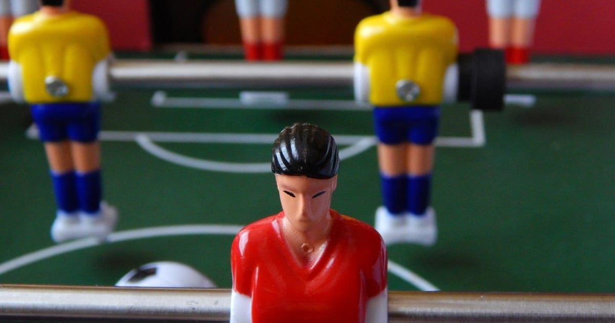 Table football players facing each other mid-match